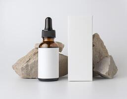 a bottle of essential oil next to some rocks photo