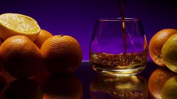 Drink on background of oranges is poured into transparent glass. Stock clip. Bar drink made of oranges. Oranges around glass with bar drink video