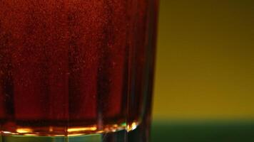 Still life with cognac. Stock clip.Orange background with a view of an alcoholic carbonated drink and small tangerines lying nearby. video