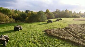 ATVs ride on green field. Clip. Top view of beautiful green field and riding ATVs. Quad bikes ride on green summer field on sunny day video