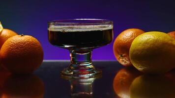Beautiful illuminated background. Stock clip.Beautiful roomy glasses with an alcoholic drink with gases on the background of tangerines and oranges video