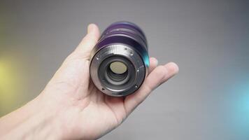 FRANCE, PARIS - MARCH 21, 2022. Large wide angle lens. ACTION. Showing a new lens on a purple background. Large zoom lens for SLR camera video