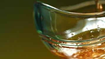 A bright glass with cognac. Stock clip.A large mug in which expensive whiskey is poured. video