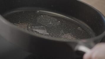 Preparation of frying products. Action.A preheated frying pan greased with oil that is turned in different directions. video