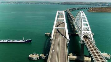 Big bridges over the sea. Shot.A helicopter view where two large bridges for cars are located above the sea where ships float and cities on the coast are visible from behind. video