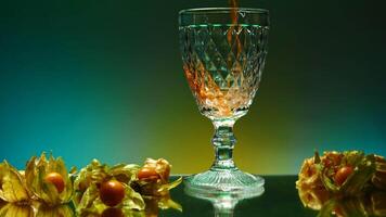 Beautiful illuminated background. Stock clip.Beautiful roomy glasses with an alcoholic drink with gases on the background of tangerines and oranges video
