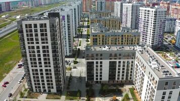 A bright bird's-eye view.Stock footage.Large high-rise buildings located in rows, next to the highway along which different cars move and a beautiful blue sky overhead. video