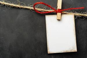 black chalkboard with red ribbon and empty card hang on rope, photo