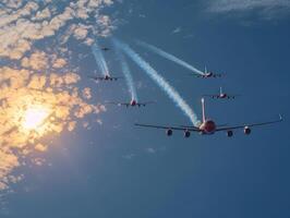 several planes fly overhead under an unusual cloudy sky, photo
