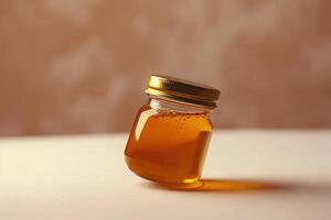 jar holding honey sitting in white table with tan wallpaper, photo