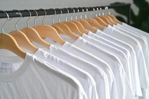 some shirts are hanging on the rack with clothes, photo