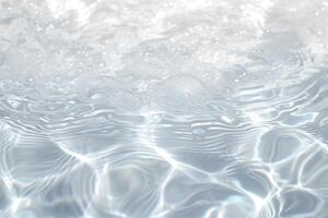 the surface of clear blue water with sun glare on it, photo