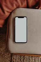 an empty cell phone on couch with pillow, photo