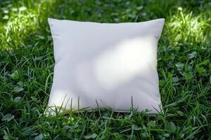 an empty white square cushion sitting in the grass, photo