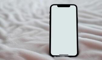 a blank white iphone next to some soft pink blankets, photo