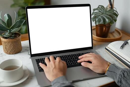 un persona trabajando en su ordenador portátil con un libro acostado al lado de, foto