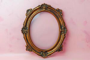 an oval gilded picture frame against a pink wall, photo