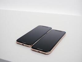 two iphones that are sitting on top of each other, photo