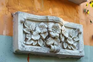 a decorative stone block on the side of a building, photo