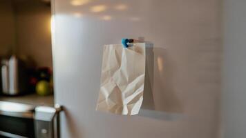 a piece of sticky paper on a refrigerator and door, photo
