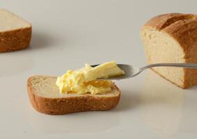 knife and butter spread on bread over a table, photo