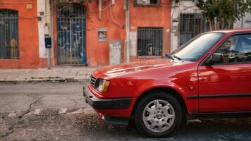 a red colored car parked along the curb, photo