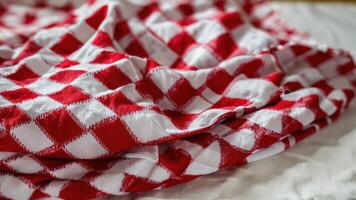 closeup of a red and white checkered blanket on a bed, photo