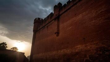the sun sets through some clouds behind a castle, photo