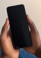 persons hand holding up an iphone in a minimal setting, photo