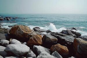 waves splash against the large rocks on a sunny day, photo