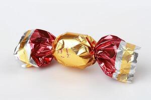 two foil wrapped chocolate candies stacked on each other, photo