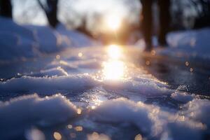 the sun rises over some melted snow as snowflakes come down, photo
