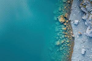 the view shows the rocks next to turquoise water, photo