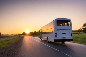 a tourist bus is traveling down the road at sunset, photo