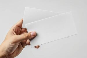 a person holding two folded papers in their left hand, photo