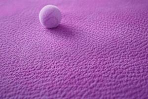 small ball on purple towel close to bed, photo