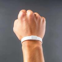 the arm with a wristband is holding onto a wii mote, photo