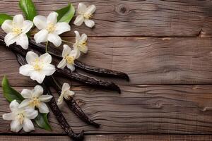 two vanilla pods and white flowers on wooden table, photo