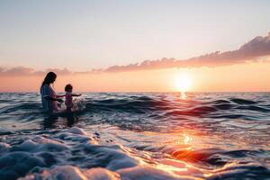 a woman and young boy standing in the ocean, looking out at the sun setting, photo