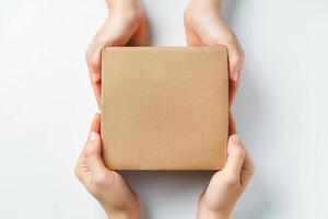 two hands holding a box as they sit on a table, photo