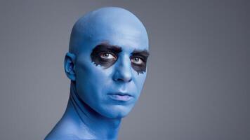 a bald man with blue paint on himself, photo