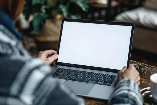 a person typing on a laptop while sitting in a chair, photo