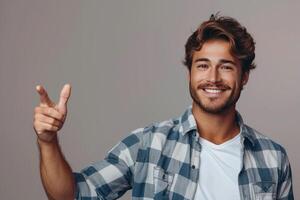 the smiling young man is showing that one hand out and making a thumbs up sign, photo