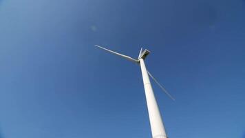 wind generator works against blue sky. blades of a wind generator rotate quickly video
