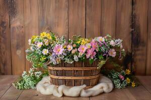 a basket with wildflowers and other wild flowers on the table, photo