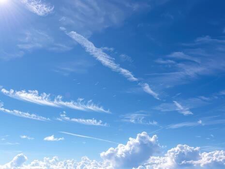 a clear blue sky with clouds and some lines in the water, photo