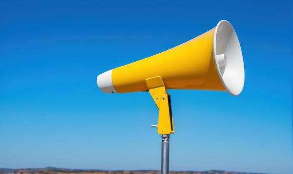 an empty yellow megaphone sitting on top of a metal pole, photo