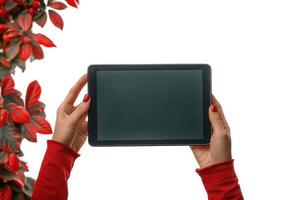 a person holding up an electronic tablet in front of some foliage, photo