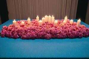 four lit candles are arranged over a floral arrangement, photo