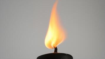 a candle burning brightly against a neutral grey sky, photo